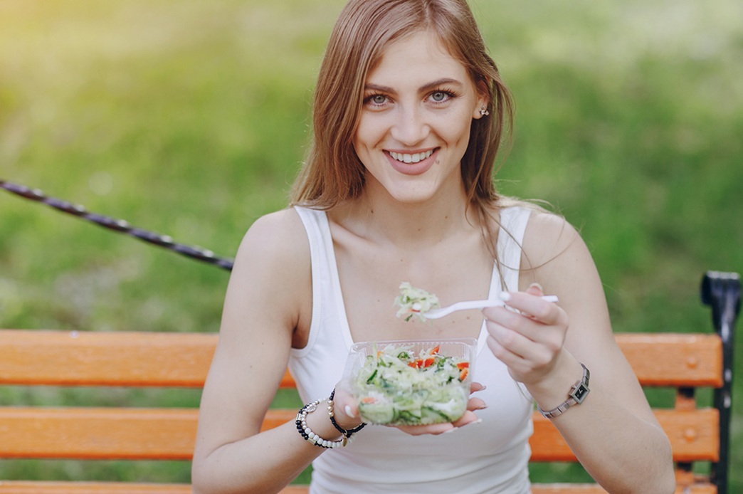 beautiful-girl-eats-salad-park-s אישה צעירה אוכלת סלט ירקות עשיר